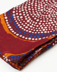 Close-up of folded Ants Nest 100% Cashmere Scarf displaying the detailed deep red and ochre Indigenous dot pattern designed by Emma Kerslake.