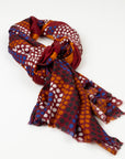 Kirrikin Ants Nest Luxury Cashmere Scarf styled in a loose knot, featuring rich burgundy, ochre, blue, and white Indigenous dot artwork by Emma Kerslake.