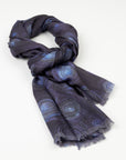 Kirrikin Luxury Cashmere Scarf styled in a loose knot on a white background, featuring dark blue and purple circular Indigenous artwork by Helena Geiger with frayed edges.