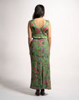 Full rear view of model wearing the green patterned Jenni maxi skirt styled with a sleeveless V-neck top.