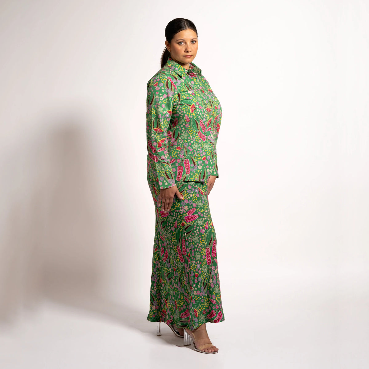 Side profile view of model wearing the green patterned Jenni maxi skirt and long sleeve blouse set.