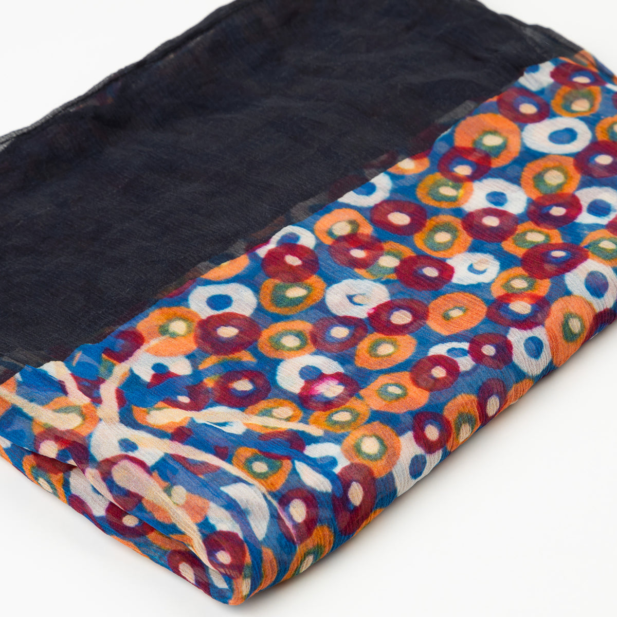 olded Native Pear Flower Luxury Cashmere Scarf by Kaye White, displaying a black fabric body with colorful circular Indigenous artwork patterns along the border.