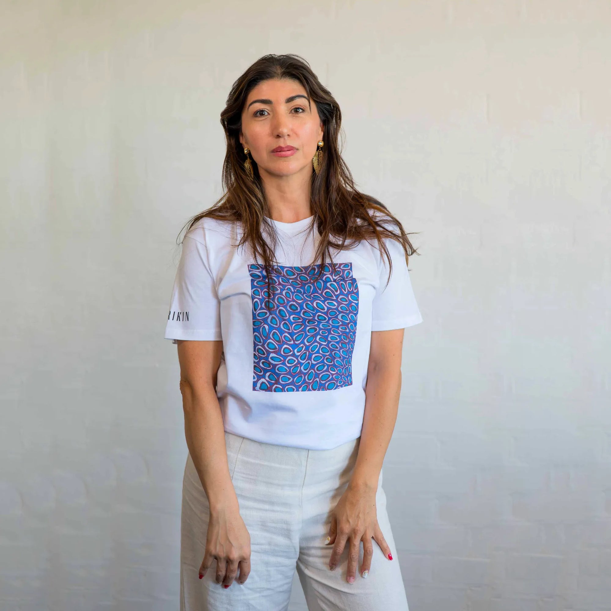 Women model wearing a casual Pilbara Wildflowers t-shirt styled with denim jeans in a natural outdoor setting.