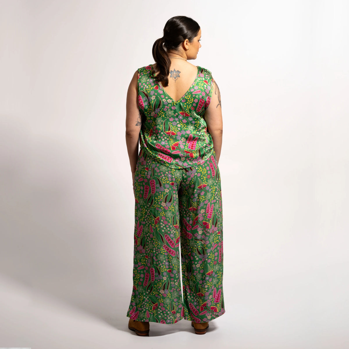 Rear full-length view showcasing the fluid drape and wide-leg fit of the Sophie Pants Boodja in green Indigenous print.