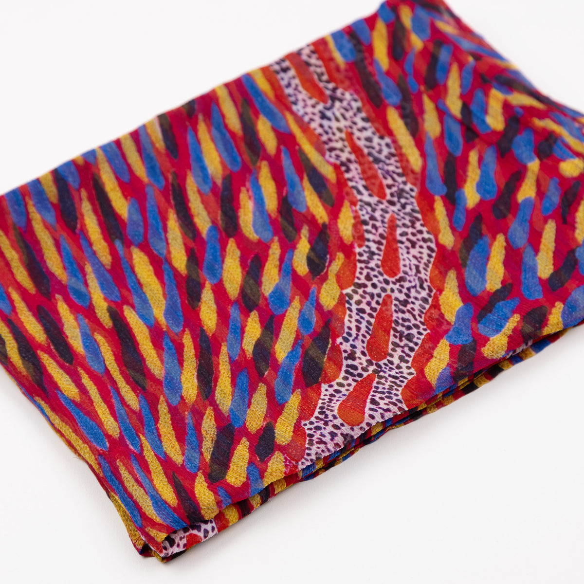 Folded Storms in the Pilbara Silk Chiffon Scarf by Kaye White, displaying vibrant red, yellow, and blue Indigenous artwork patterns.