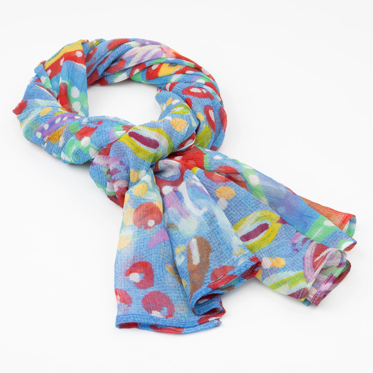 The luxury cashmere scarf with a vibrant Pilbara wildflower design by Sally White, draped in a loose knot.