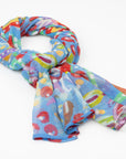 The luxury cashmere scarf with a vibrant Pilbara wildflower design by Sally White, draped in a loose knot.